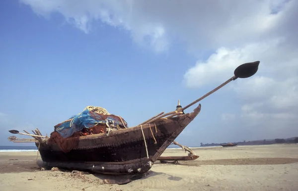 stock image a  wood fishingboat at a sandy Beach with Landscape and Coast at the Town of Vagator in the Province of Goa in India,  India, Goa, April, 1996