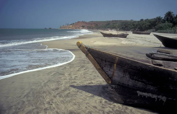 stock image a  wood fishingboat at a sandy Beach with Landscape and Coast at the Town of Vagator in the Province of Goa in India,  India, Goa, April, 1996