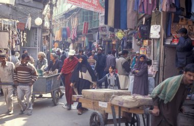 Delhi 'nin eski bir kasabası olan Delhi' de, eski bir taksi ile bir pazar caddesinde trafik. Hindistan, Delhi, Şubat 1998