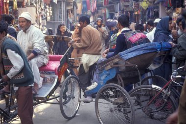 Delhi 'nin eski bir kasabası olan Delhi' de, eski bir taksi ile bir pazar caddesinde trafik. Hindistan, Delhi, Şubat 1998