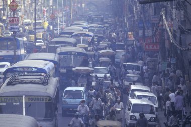 a air pollution with traffic on a long road in the city of Old Delhi in India.  India, Delhi, February, 1998 clipart