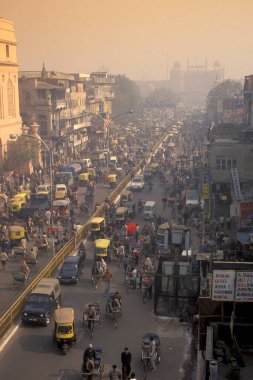 a air pollution with traffic on a long road in the city of Old Delhi in India.  India, Delhi, February, 1998 clipart