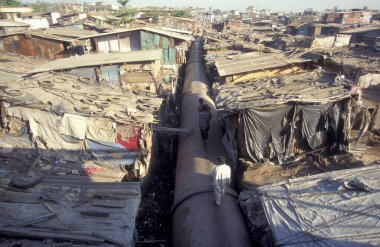 Hindistan 'ın Mumbai şehrinin merkezindeki gecekondu mahallesinde bir su hattı. Hindistan, Mumbai, Mart 1998