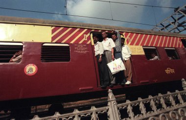 Mumbai tren istasyonuna ya da Hindistan 'ın Mumbai şehir merkezindeki Chhatrapati Shivaji Terminus' a giden aşırı yüklü bir tren. Hindistan, Mumbai, Mart 1998