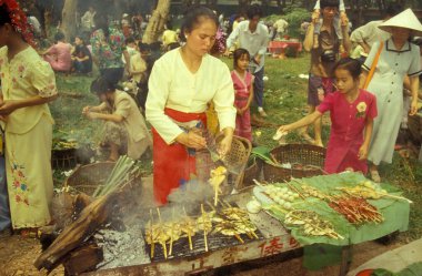 Çin 'in doğusundaki Yunnan eyaletinin Xishuangbanna bölgesindeki Jinghong kasabası yakınlarındaki ilkbahar ve su festivalinde geleneksel bir gıda ve market. Çin, Yunnan, Nisan 1996