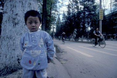 Doğu Asya 'da, Çin' in Yunnan ilindeki Kunming şehrindeki bir yolda bir çocuk. Çin, Yunnan, Nisan 1996