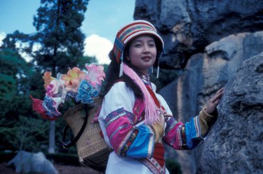 people in traditional costume of chinese minorities posing at the Shilin Stone Fosrest Park near the City of Kunming in the province of Yunnan in China in east asia.  China, Yunnan, April, 1996 clipart