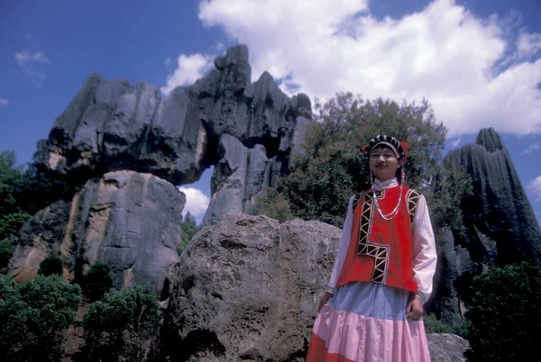 stock image people in traditional costume of chinese minorities posing at the Shilin Stone Fosrest Park near the City of Kunming in the province of Yunnan in China in east asia.  China, Yunnan, April, 1996