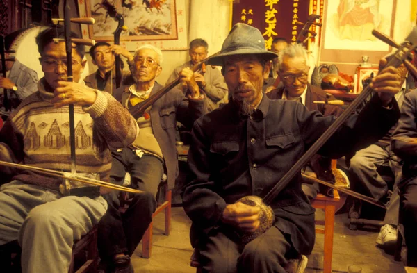 stock image Traditional Music at a ceremony in a old Temple in traditional costum in the Town of Lijiang on the Er Hai Lake in the province of Yunnan in China in east asia.  China, Yunnan, April, 1996