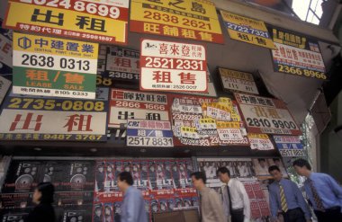 Hong Kong 'un Hong Kong şehrindeki merkezi Hong Kong' da mülk reklamları, evler ve odalar olan bir duvarın önündeki insanlar. Çin, Hong Kong, Mayıs 1997