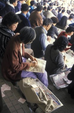 İnsanlar Hongkong yakınlarındaki Sha Tin 'de bir at yarışı stadyumunda at yarışı oynandığına dair iddiaya girdiler. Çin, Hong Kong, Mayıs 1997