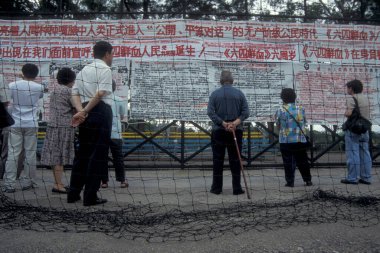 Hong Kong 'un Hong Kong şehrinde Hongkong' un Çin 'e teslim edilmesinden önce Çin' de demokratlık yürüyüşünde olan insanlar ve istihbaratlar duvarda asılı. Çin, Hong Kong, Mai, 1997