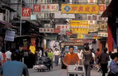 Hong Kong 'daki Kowloon şehrindeki eski bir alışveriş caddesinde yaşayan insanlar. Çin, Hong Kong, Aralık 1997