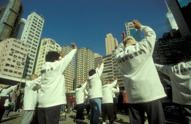 Hong Kong 'da, Hong Kong şehrindeki Central Hong Kong' un Skyline 'ının önünde insanlar egzersiz yapıyor ve Tai Chi yapıyor. Çin, Hong Kong, Mayıs 1997