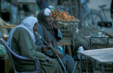 Kuzey Afrika 'daki Mısır' ın Kahire kentindeki ana çarşı veya pazardaki geleneksel çay ve kahve dükkanındaki erkekler. Mısır, Kahire, Mart 2000