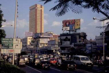 Hindistan 'ın Karnataka eyaletindeki Bangalore şehrinde Dükkanlar ve İnsanlarla bir alışveriş caddesi. Hindistan, Bangalore, Nisan 1998