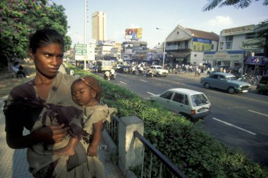 Hindistan 'ın Karnataka eyaletinin Bangalore şehrinde çocuğuyla birlikte alışveriş ve trafik yolunda olan Hintli bir kadın. Hindistan, Bangalore, Nisan 1998