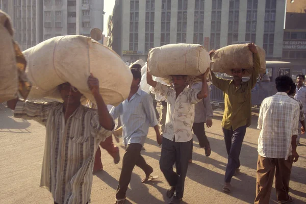 人々はインドのグジャラート州のスラト市の貿易市場でコットンで袋を運びます インド グルジャラート 1998年4月 — ストック写真