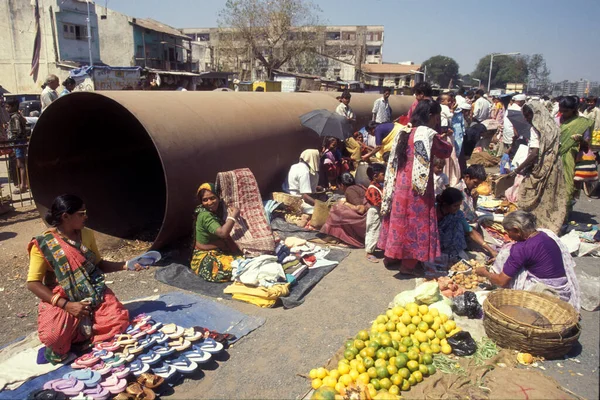 stock image people in front of a large water pipe at the Food market in the city of Surat in the Province Gujarat in India.  India, Gujarat, April, 1998