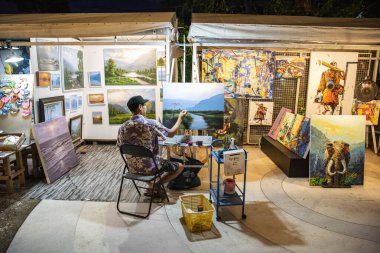 Tayland 'ın Prachuap Khiri Khan ilindeki Hua Hin şehri yakınlarındaki Cicada Gece Pazarı' ndaki sanat ve el yapımı pazarında ressam ve sanatçı.