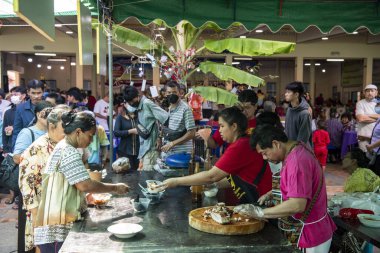 İnsanlar Tayland 'da Prachuap Khiri Han' ın başkenti Hua Hin 'deki Wat Hua Hin şehrinde düzenlenen bir tapınak töreninde bedava Tayland yemeklerini yiyorlar.