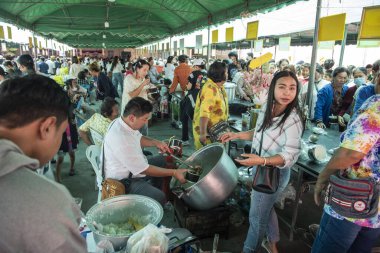 İnsanlar Tayland 'da Prachuap Khiri Han' ın başkenti Hua Hin 'deki Wat Hua Hin şehrinde düzenlenen bir tapınak töreninde bedava Tayland yemeklerini yiyorlar.