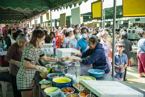 İnsanlar Tayland 'da Prachuap Khiri Han' ın başkenti Hua Hin 'deki Wat Hua Hin şehrinde düzenlenen bir tapınak töreninde bedava Tayland yemeklerini yiyorlar.