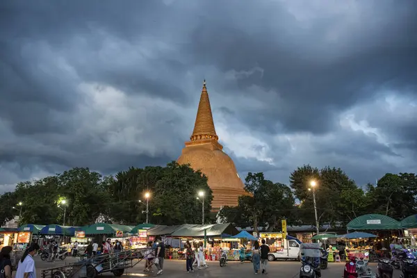 Tayland, Nakhon Pathom - 11 Kasım 2023: Nakhon Pathom 'daki Phra Pathom Chedi ve Tayland' daki Nakhon Pathom 'un önündeki gece pazarı.