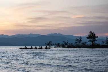 Tayland 'ın Phetchaburi ilindeki Kaeng Krachan Milli Parkı' ndaki Kaeng Krachan Barajı 'nda uzun bot kürek çekme takımı antrenmanında. Tayland, Phetchaburi, 19 Kasım 2023