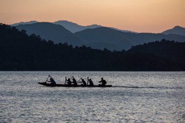 Tayland 'ın Phetchaburi ilindeki Kaeng Krachan Milli Parkı' ndaki Kaeng Krachan Barajı 'nda uzun bot kürek çekme takımı antrenmanında. Tayland, Phetchaburi, 19 Kasım 2023