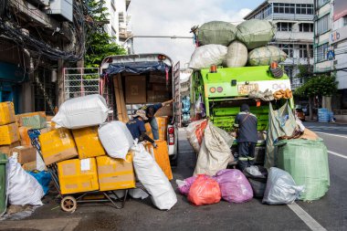 Bir nakliye aracı, sol, bir çöp ve geri dönüşüm kamyonu, sağ, Çin 'deki Yaowarat Yolu' nda, Tayland 'ın Bangkok şehrinde. Tayland, Bangkok, 7 Kasım 2023