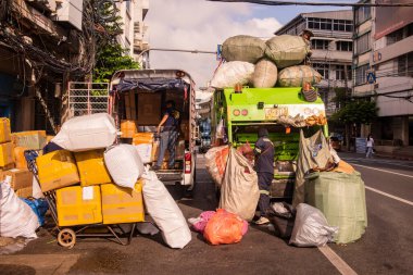 Bir nakliye aracı, sol, bir çöp ve geri dönüşüm kamyonu, sağ, Çin 'deki Yaowarat Yolu' nda, Tayland 'ın Bangkok şehrinde. Tayland, Bangkok, 7 Kasım 2023