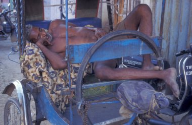 Riksha Taksi Şoförü Hindistan 'ın Tamil Nadu ilindeki Chennai şehrinde riksha üzerinde uyuyor. Hindistan, Chennai, Nisan 1998