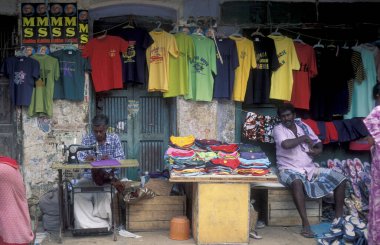 Erkekler, Hindistan 'ın Tamil Nadu ilindeki Chennai şehrindeki bir pazar caddesindeki Tekstil Terzisinde. Hindistan, Chennai, Nisan 1998