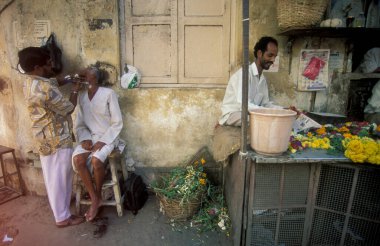 Hindistan 'ın Tamil Nadu ilindeki Chennai şehrindeki bir market sokağındaki bir berber dükkanında. Hindistan, Chennai, Nisan 1998