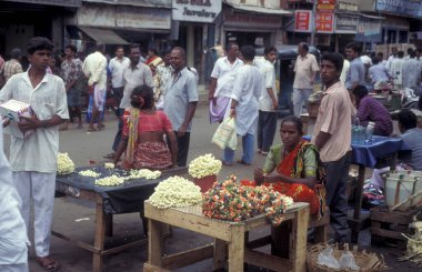 Hindistan 'ın Tamil Nadu ilindeki Chennai şehrindeki bir sokak ve sokak arasında kadınlar çiçek satıyor. Hindistan, Chennai, Nisan 1998