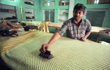 Aile Fabrikası 'ndaki bir adam Hindistan' ın Karnataka eyaletinin Mysore şehrinde Batik Tekstil baskısını iş başında yaptı. Hindistan, Mysore, Mart 1998   