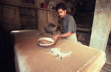 Aile Fabrikası 'ndaki bir adam Hindistan' ın Karnataka eyaletinin Mysore şehrinde Batik Tekstil baskısını iş başında yaptı. Hindistan, Mysore, Mart 1998   