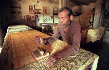Aile Fabrikası 'ndaki bir adam Hindistan' ın Karnataka eyaletinin Mysore şehrinde Batik Tekstil baskısını iş başında yaptı. Hindistan, Mysore, Mart 1998   