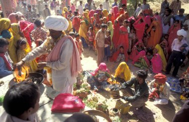 Geleneksel giyinmiş Rajasthani halkı, Hindistan 'ın Rajasthan ilindeki Pushkar kasabasında düzenlenen geleneksel cenaze töreninden sonra evlerine dönüyorlar. Hindistan, Pushkar, Ocak 1998