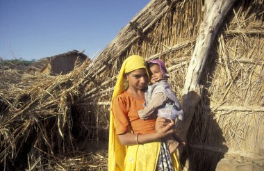 Hindistan 'ın Rajasthan ilindeki Jaisalmer kasabasında bebeğiyle birlikte bir Rajasthani kadının portresi. Hindistan, Jaisalmer, Ocak 1998