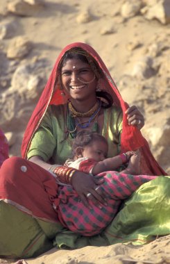 Hindistan 'ın Rajasthan ilindeki Jaisalmer kasabasında bebeğiyle birlikte bir Rajasthani kadının portresi. Hindistan, Jaisalmer, Ocak 1998