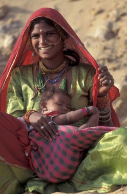 Hindistan 'ın Rajasthan ilindeki Jaisalmer kasabasında bebeğiyle birlikte bir Rajasthani kadının portresi. Hindistan, Jaisalmer, Ocak 1998