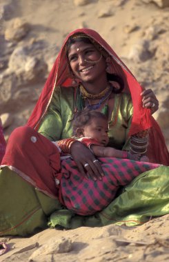 Hindistan 'ın Rajasthan ilindeki Jaisalmer kasabasında bebeğiyle birlikte bir Rajasthani kadının portresi. Hindistan, Jaisalmer, Ocak 1998
