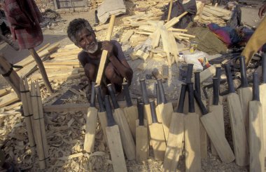 Hindistan 'ın Rajasthan eyaletindeki Jaisalmer şehrindeki bir fabrikada yeni bir kriket sopası oyan bir adam. Hindistan, Jaisalmer, Ocak 1998