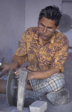 Working People in a Factory of gemstone cutting in the City of Jaipur in the Province of Rajasthan in India.  India, JAIPUR, January, 1998 clipart