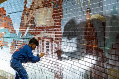Sanatçı, Tayland 'ın kuzeyindeki Phitsanulok ili ve Nan Nehri' nde duvar boyuyor. Tayland, Phitsanulok, Kasım 29, 2024.