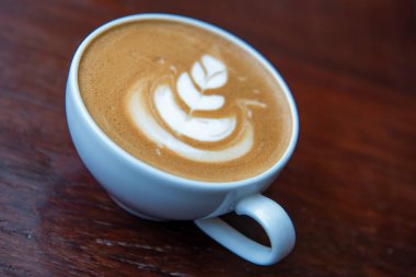 Bir fincan kapuçino ahşap tablo