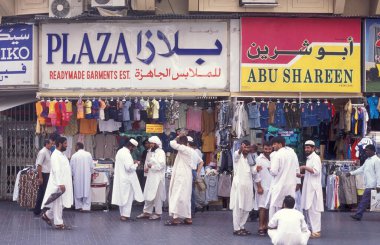 BAE, Dubai - 1 Ekim 2004: Souq ve Market in Old Town ve Dubai 'deki Bur Dubai alışveriş caddelerindeki insanlar.  