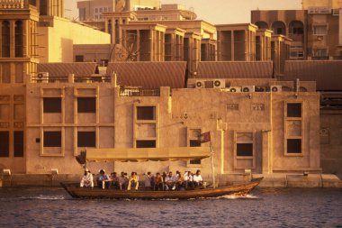 Arabistan Körfezi 'nde Arap Emirlikleri Dubai şehir eski kasabasında Dubai dere üzerinde bir şehir teknesi ve feribot.